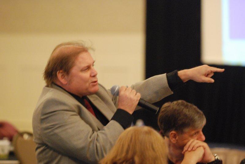 Man with his arm reached forward and talking to the group